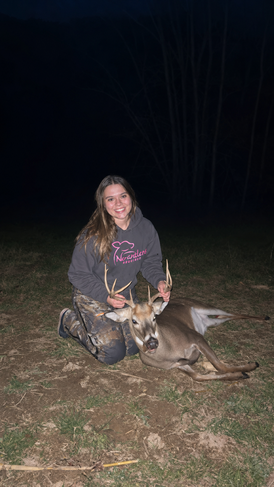 Founder with a harvested buck, wearing a No Antlers Required hoodie